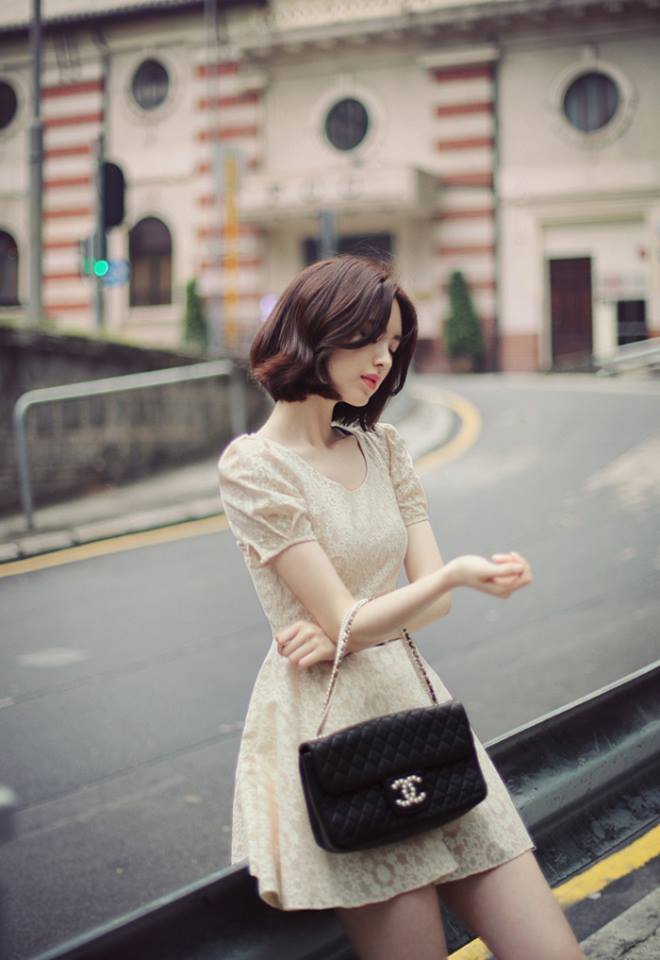 Hình ảnh một cô gái xinh xắn với mái tóc ngắn che mặt trên phố